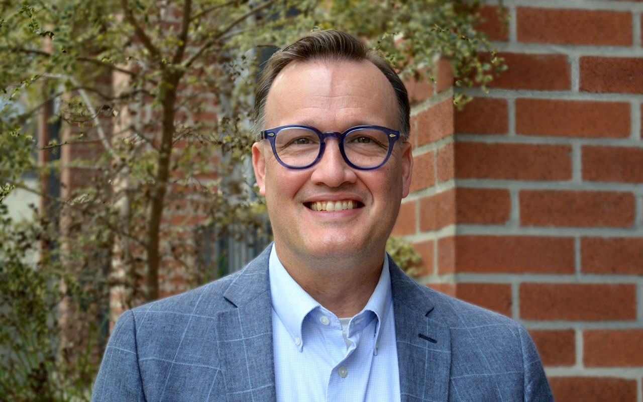 John Brown: man wearing glasses, light blue shirt and blue-gray sport coat