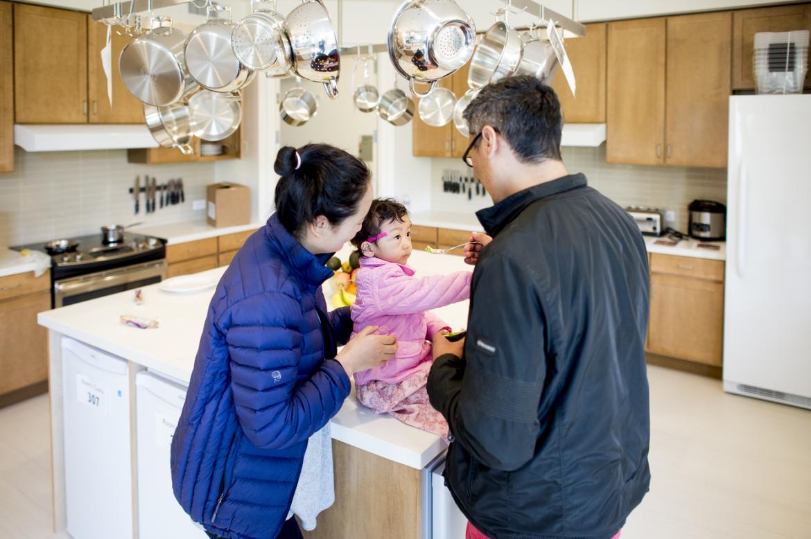 parents caring for a child in a kitchen