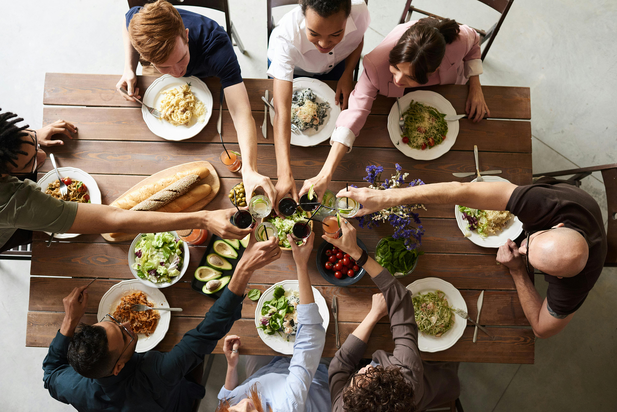 Group of people toasting over a meal at a dining room table