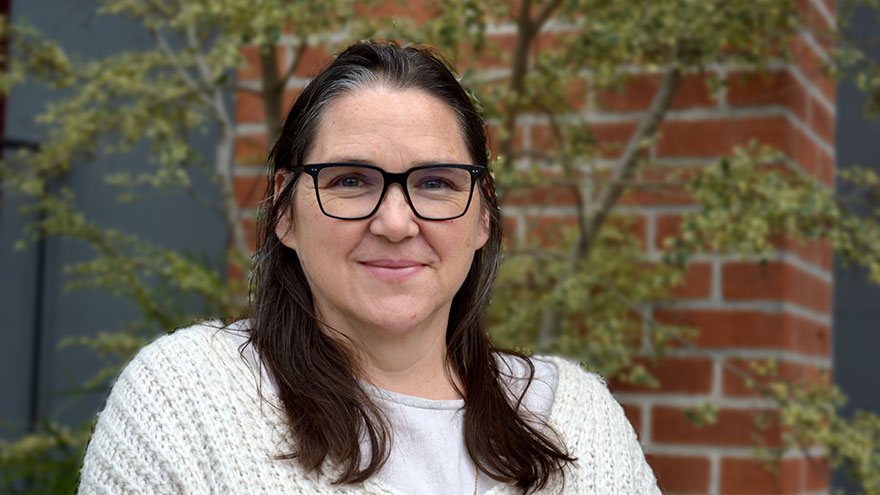 Sabina Brown — woman with dark hair and glasses, wearing white sweater