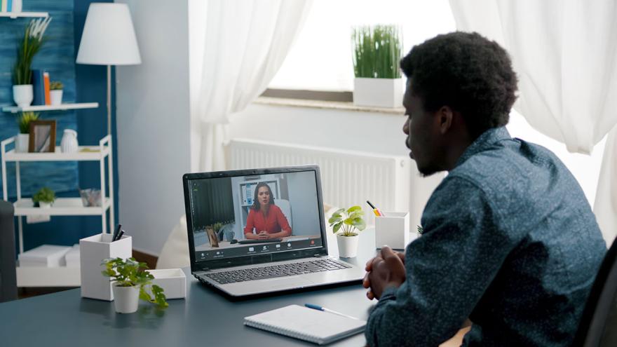 man conducts videochat on laptop