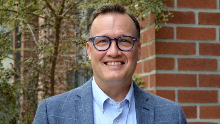 John Brown: man wearing glasses, light blue shirt and blue-gray sport coat