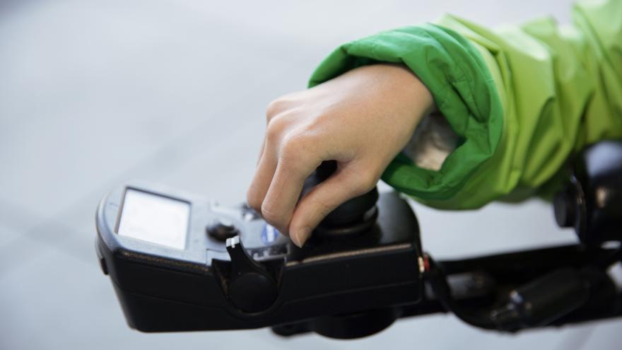 A person's hand controlling motorized chair