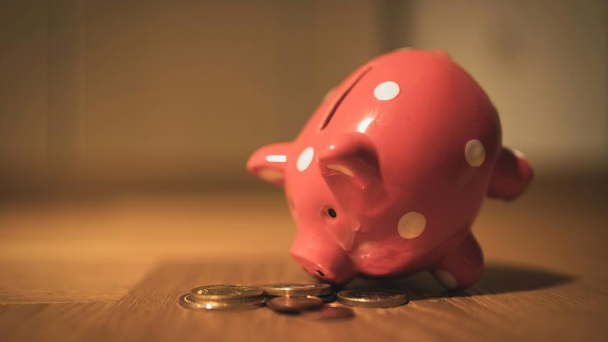 red piggy bank and coins sit on floor