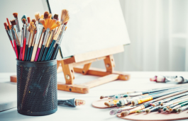 Paintbrushes in cup on an art desk