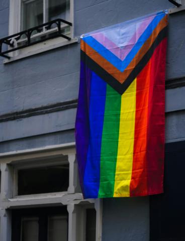 Pride flag hanging off a building