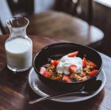 Breakfast of milk in a glass and yogurt and fruit in a bowl