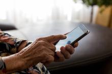 A hand taps on a cell phone