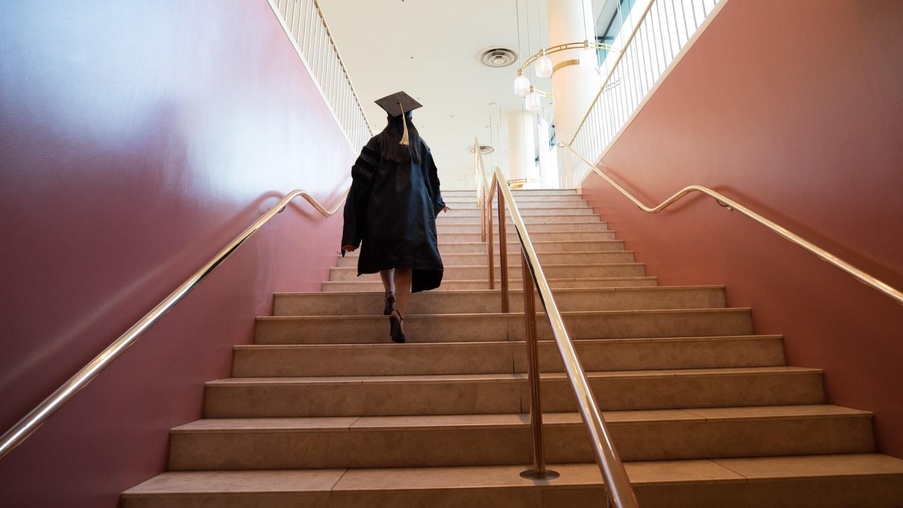Graduate walking up stairs