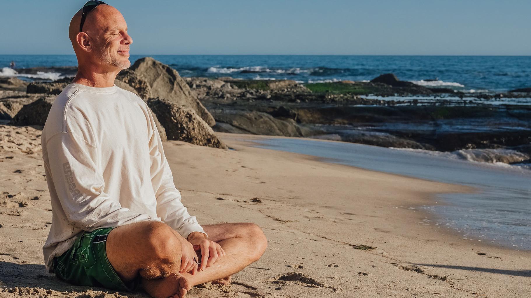 Man meditates at the beach