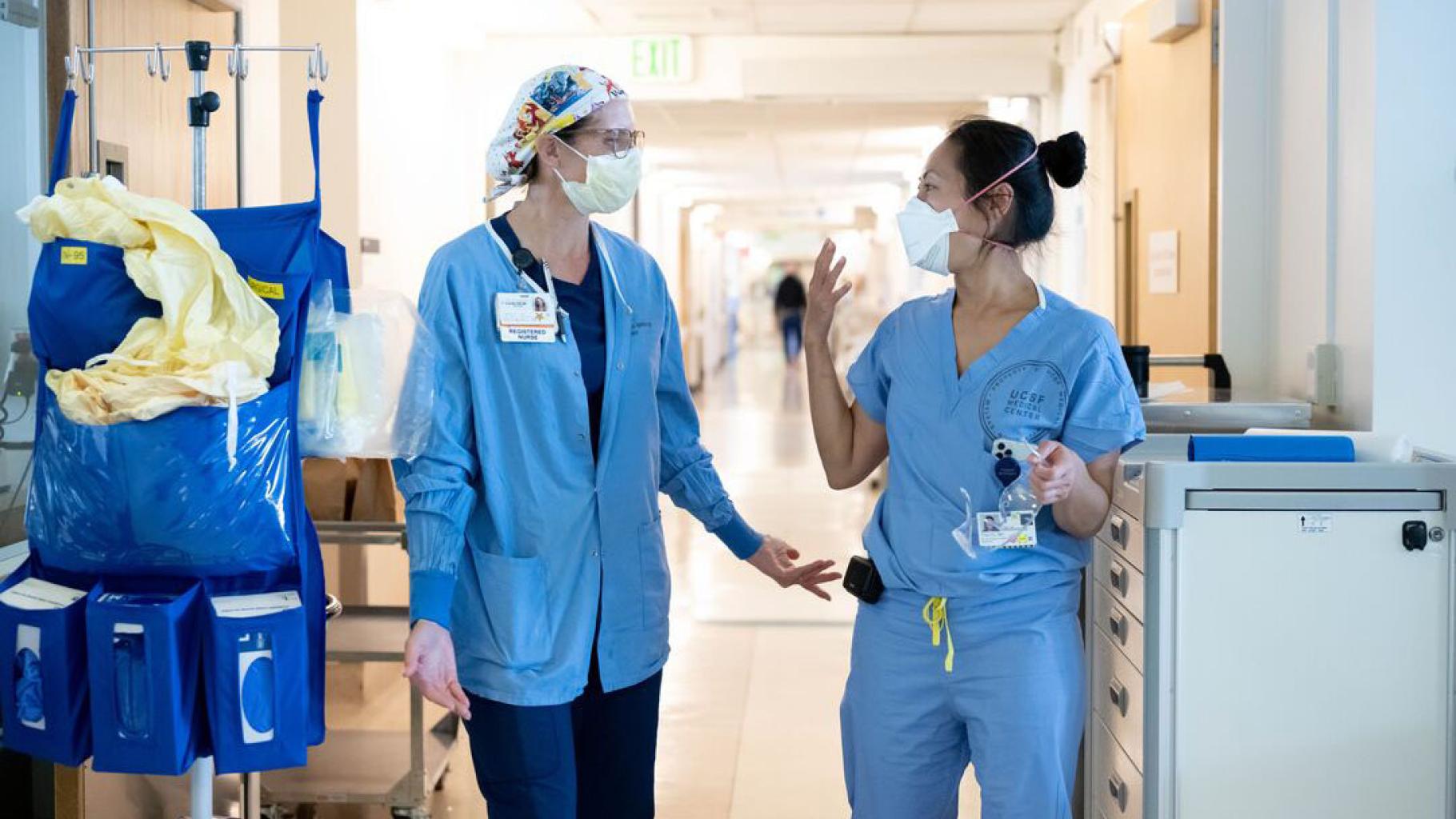 Two Health employees chat in the hallway