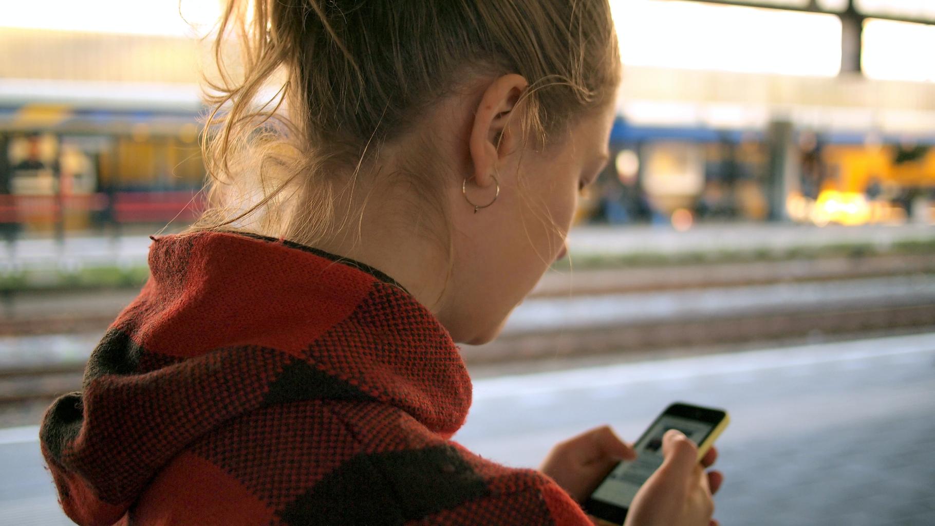 Person at train station checks phone