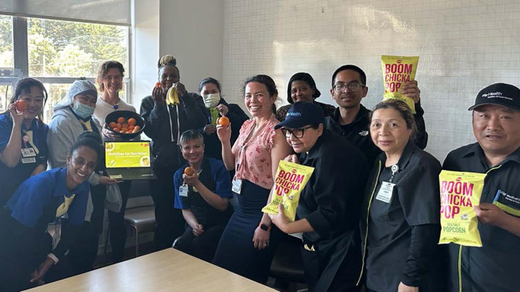 Group holding up bags of popcorn